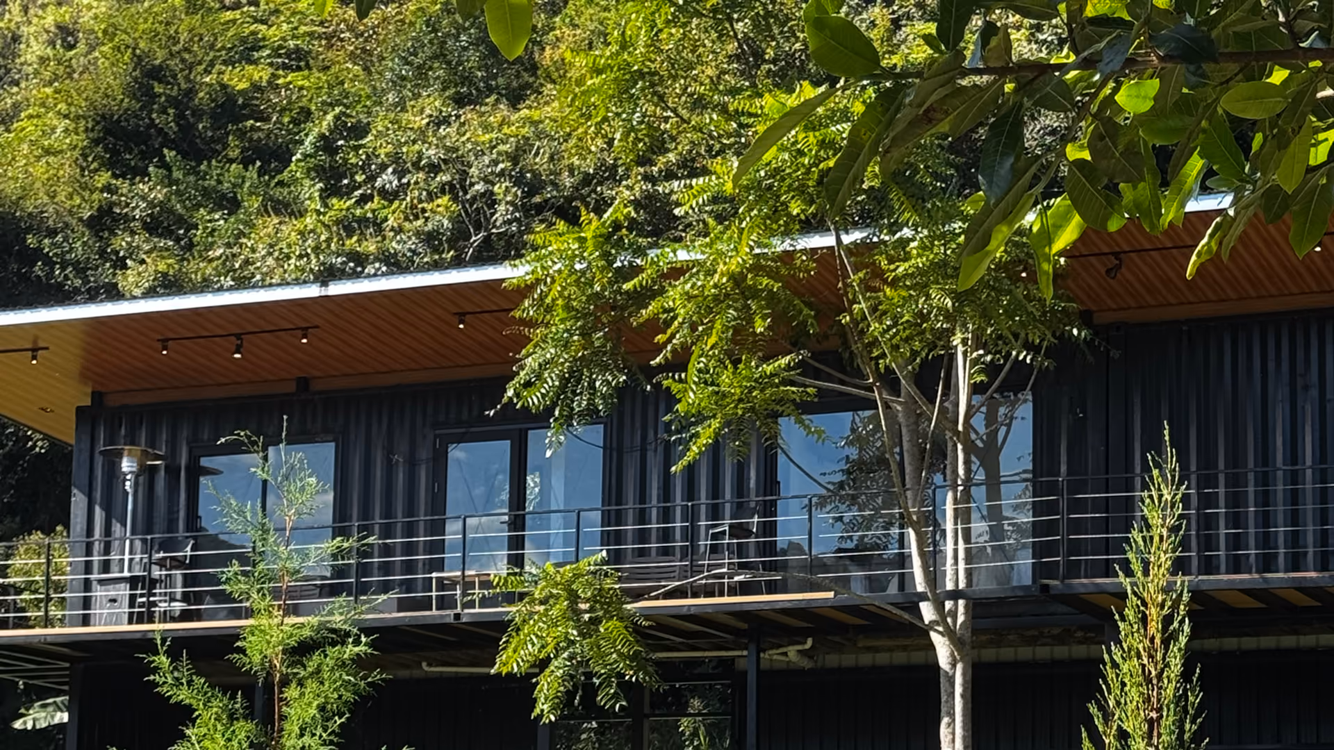 Planta alta con ventanales y terraza frente al bosque
